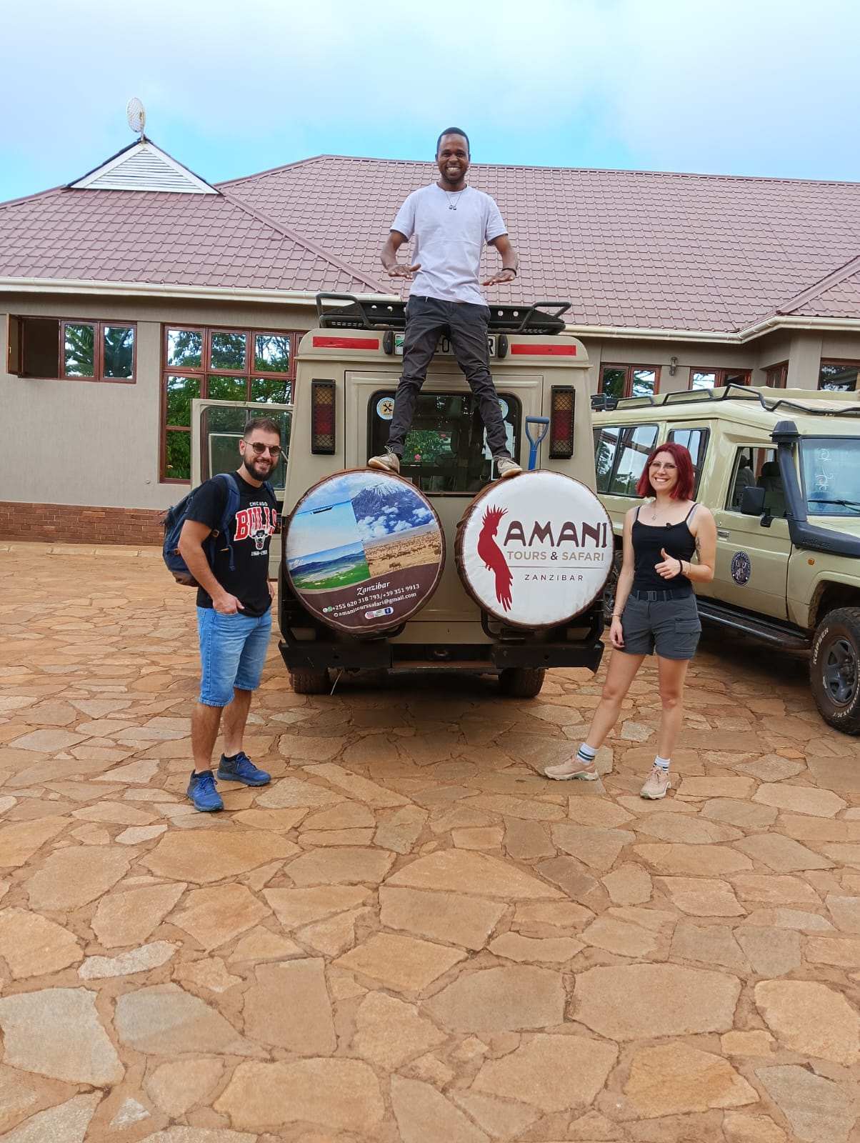 Viaggiatori con il team locale e i mezzi safari Amani Tours